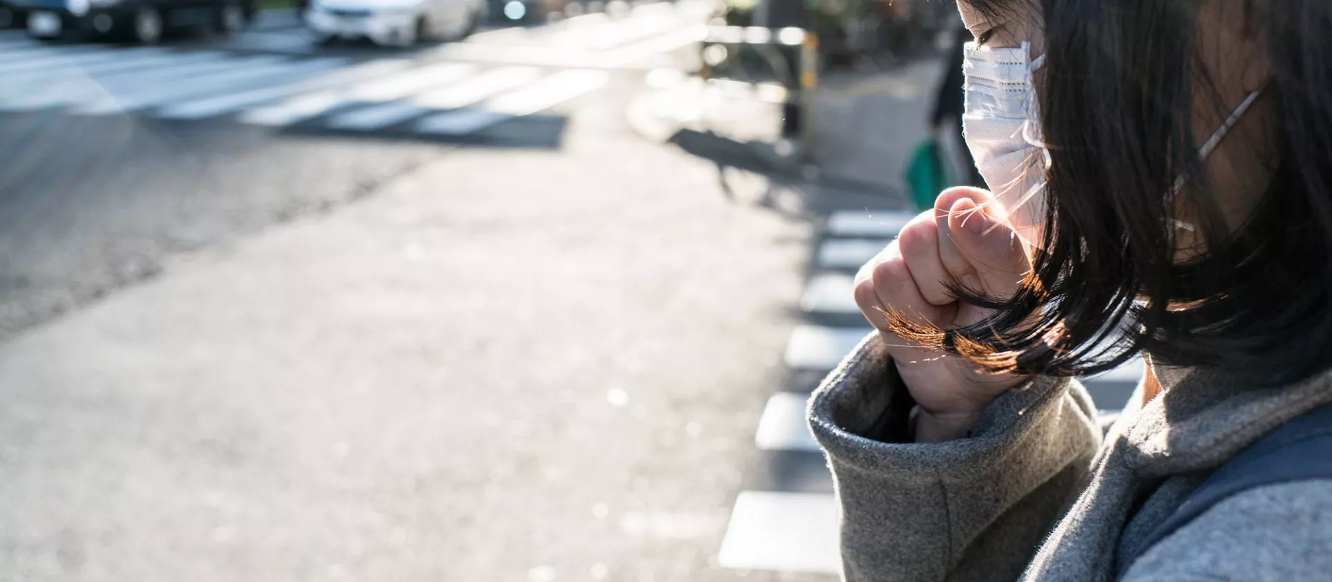 Een jonge vrouw met een mondmasker op straat