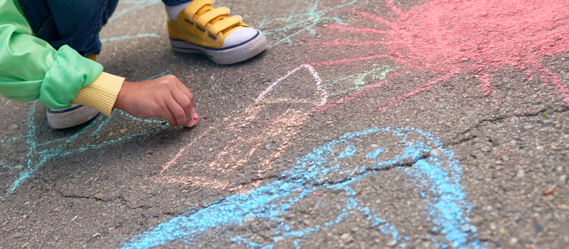 Kind dat krijttekeningen maakt op de stoep. Kind dat krijttekeningen maakt op de stoep.