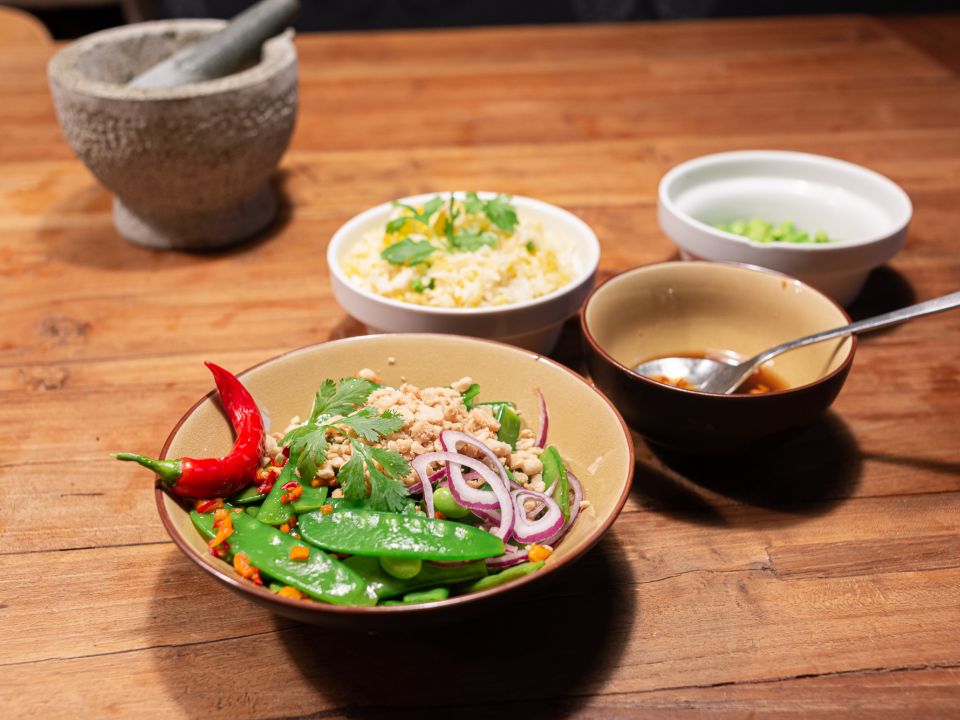Thaise bonen salade in een kommetje gegarneerd met peper en rode ui