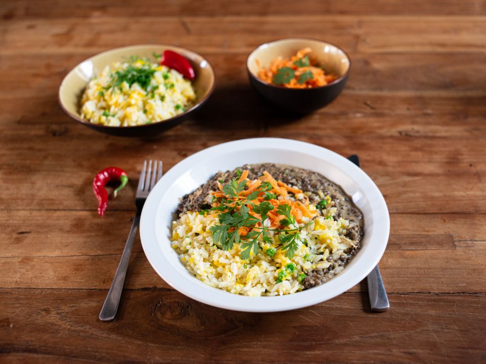 Linzencurry met wortelpickle geserveerd met een blaadje koriander