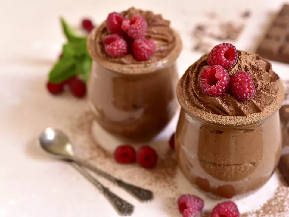 Chocolademousse met rode peper en frambozen in glazen kommetjes Chocolademousse met rode peper en frambozen in glazen kommetjes