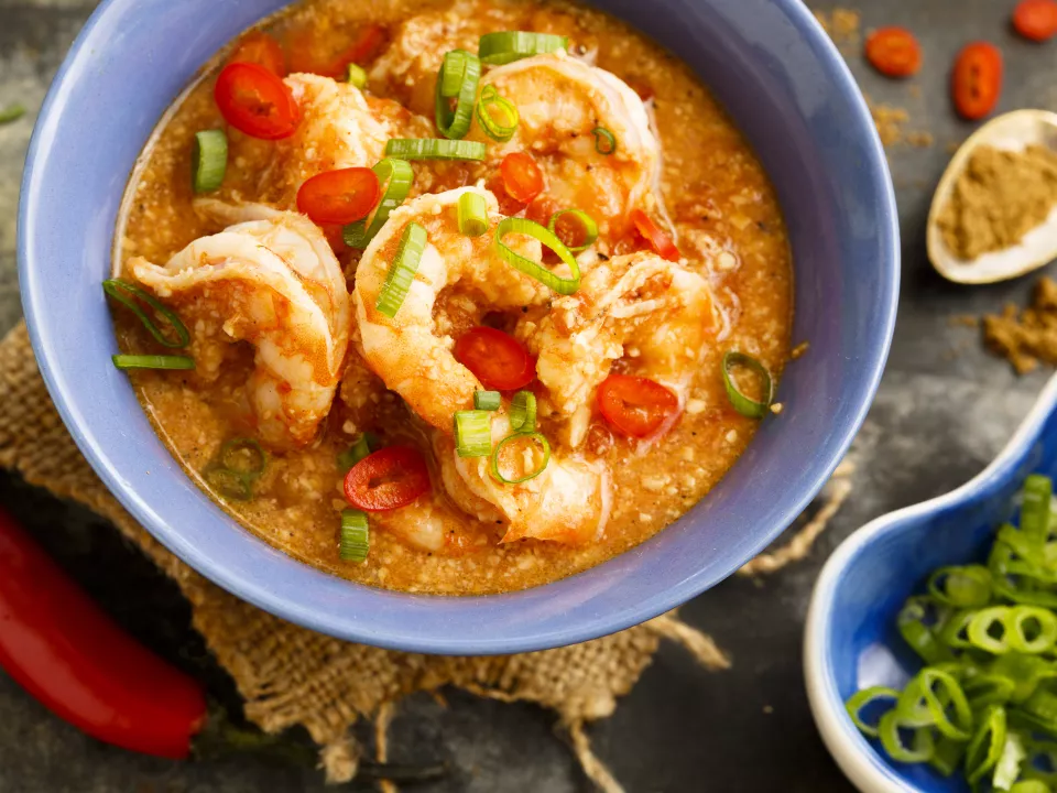 Klaargemaakte scampi met rode curry in een diep bord Klaargemaakte scampi met rode curry in een diep bord